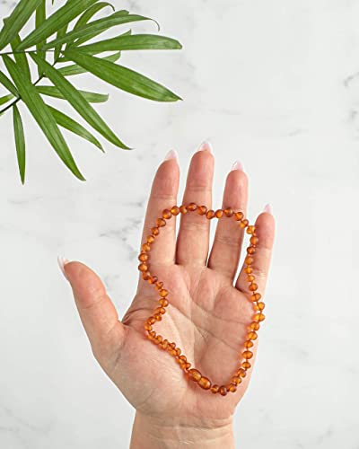 Hand holding the necklace so the short strand and clasp can be seen together